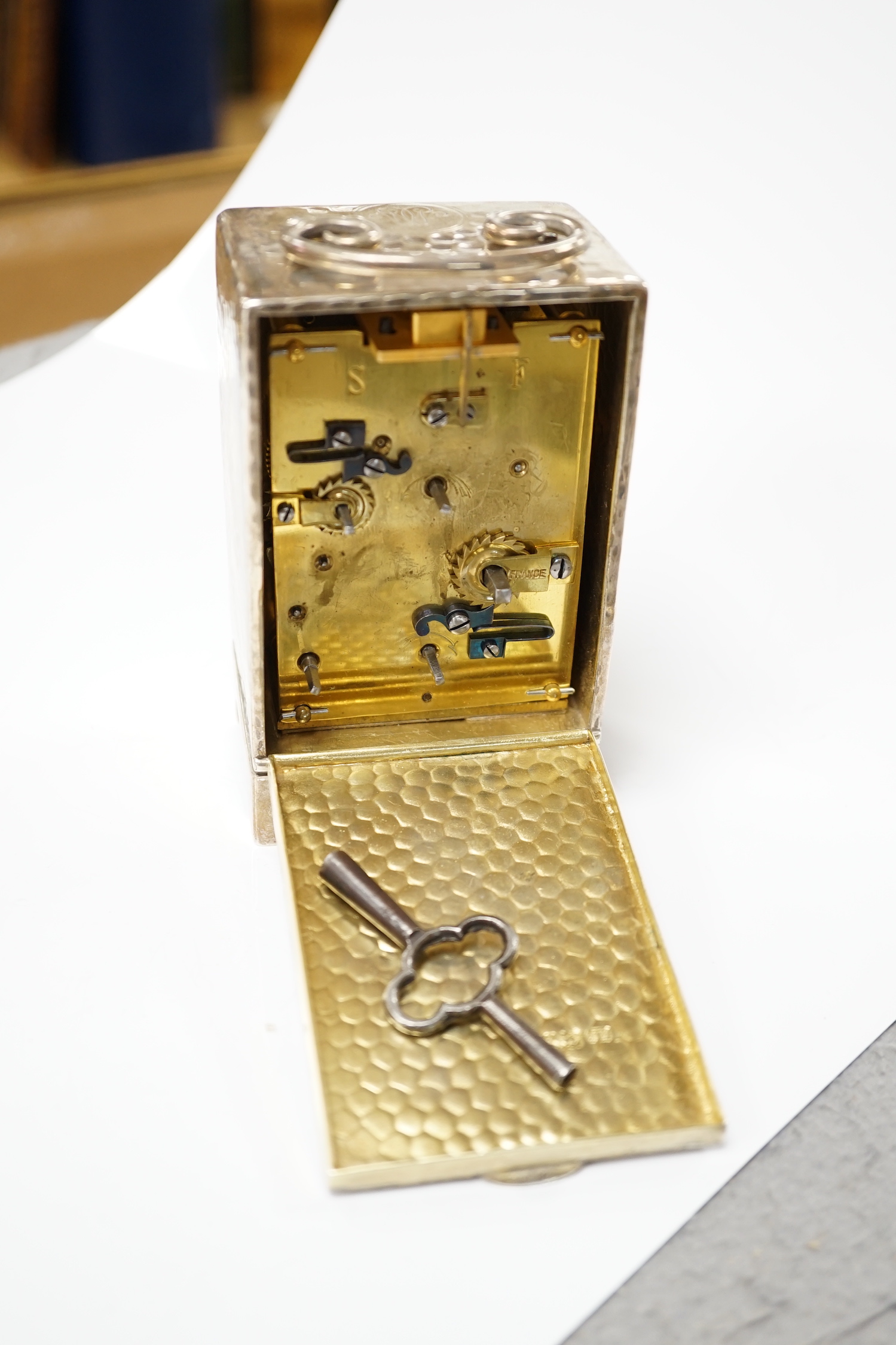 An Edwardian planished silver alarm carriage timepiece, Arthur Baume & Co, London, 1905, height 11cm.